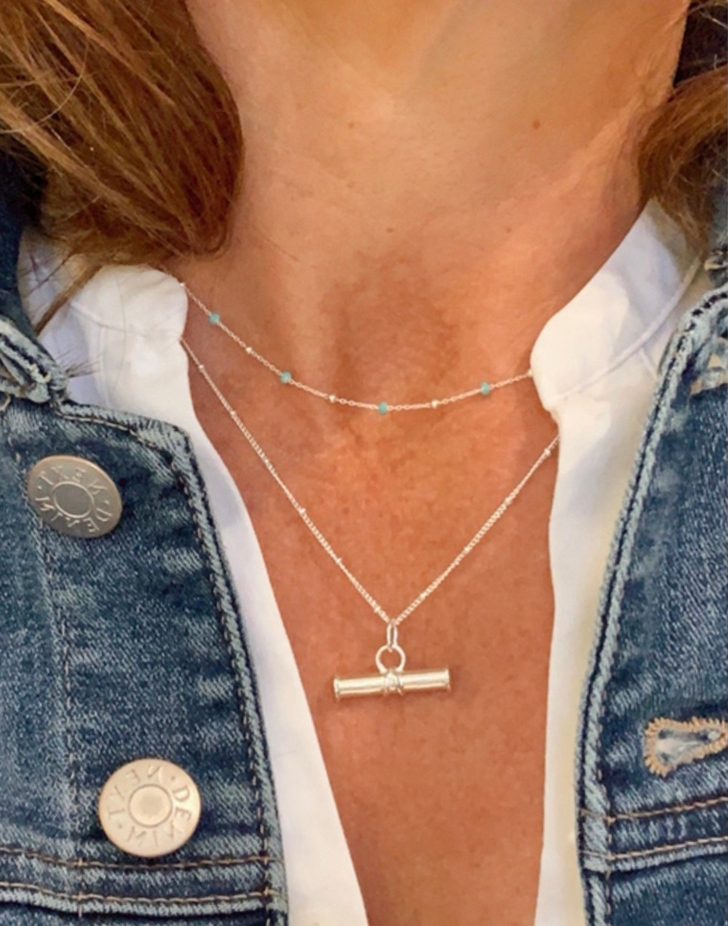 model wears light turquoise enamel necklace with silver t bar