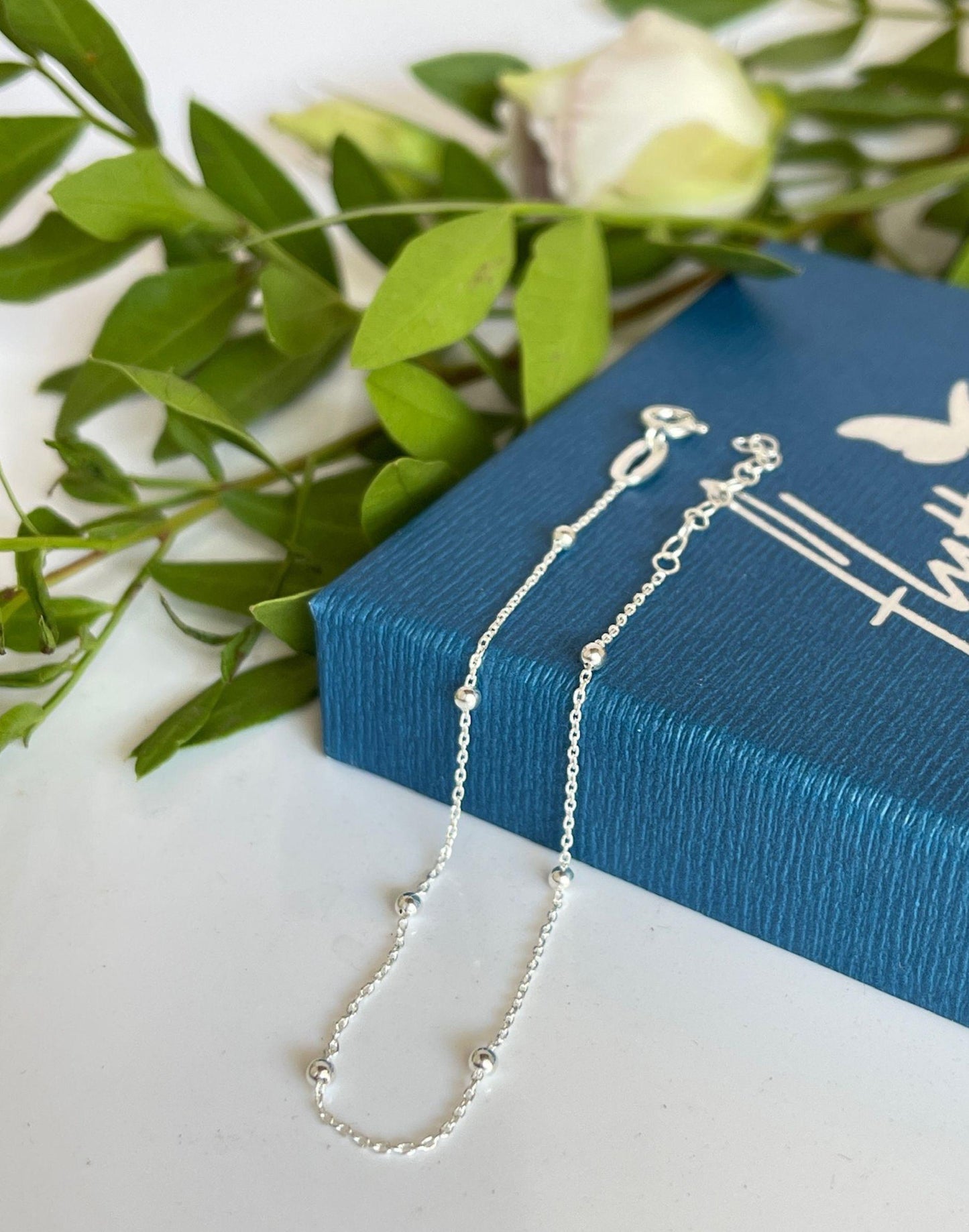 Silver satellite chain draped over gift box
