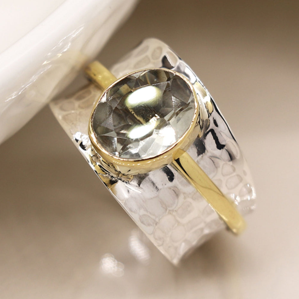 Silver spinning ring with green amethyst with a textured design on a light background