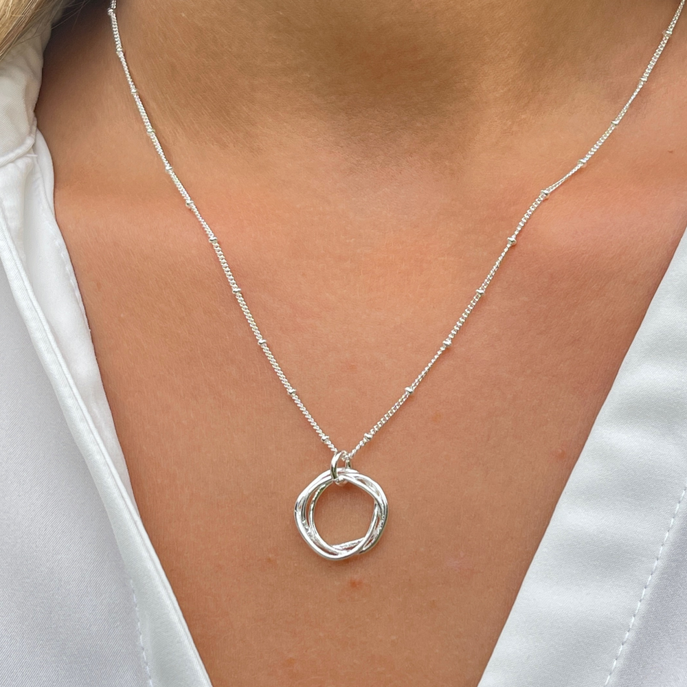 Close up of silver twisted circle necklace