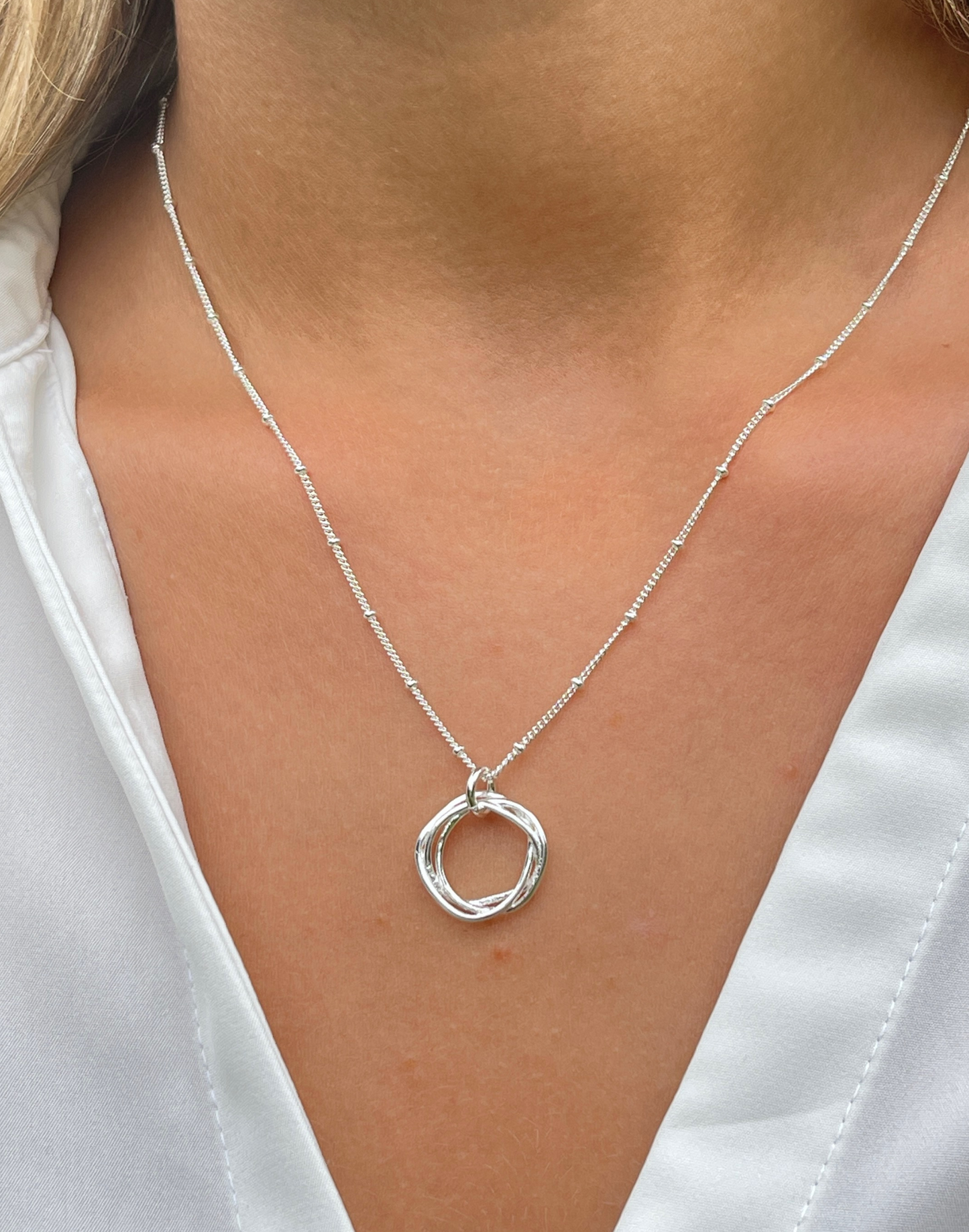 Close up of silver twisted circle necklace
