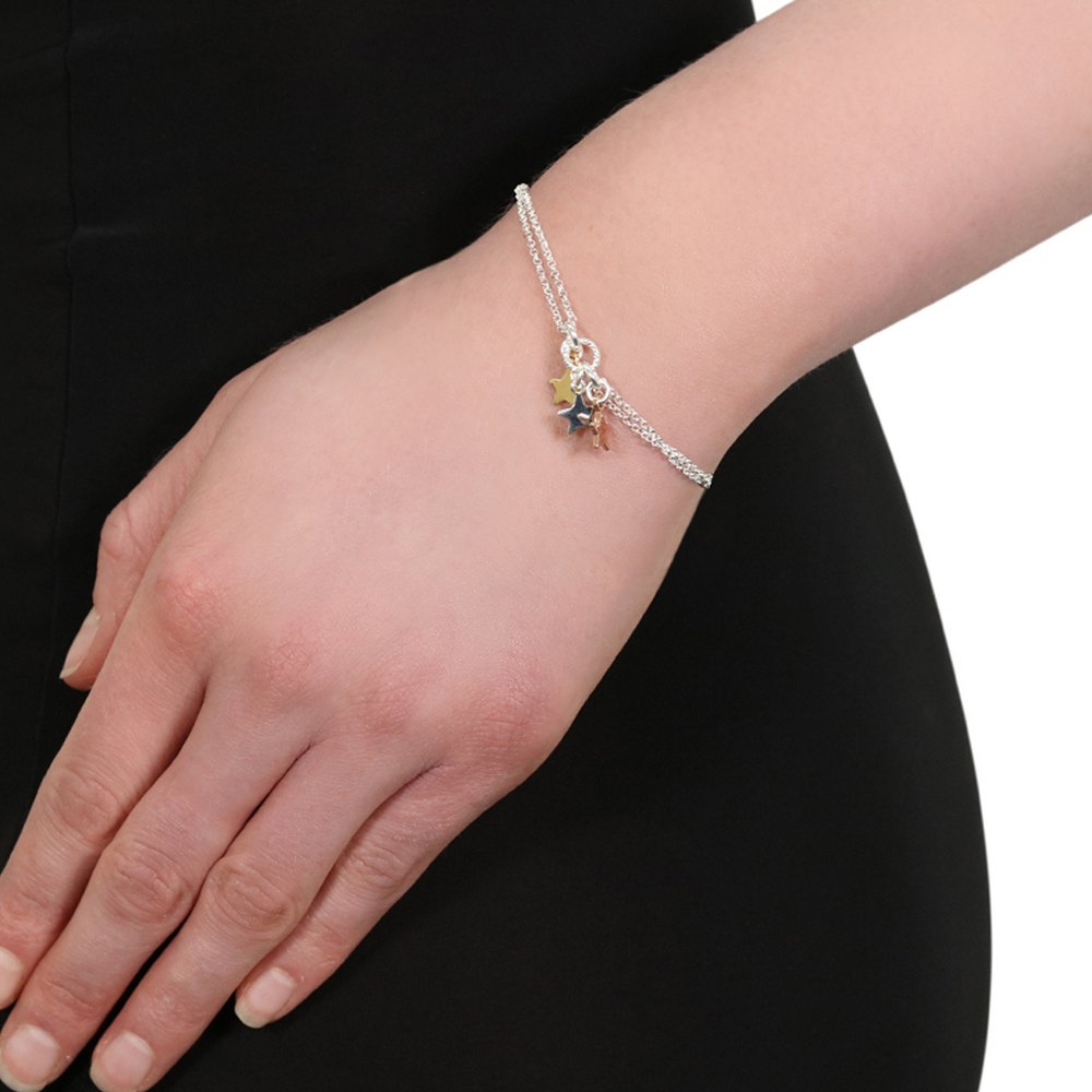 Stella star silver charm bracelet with 3 star charms on a wrist
