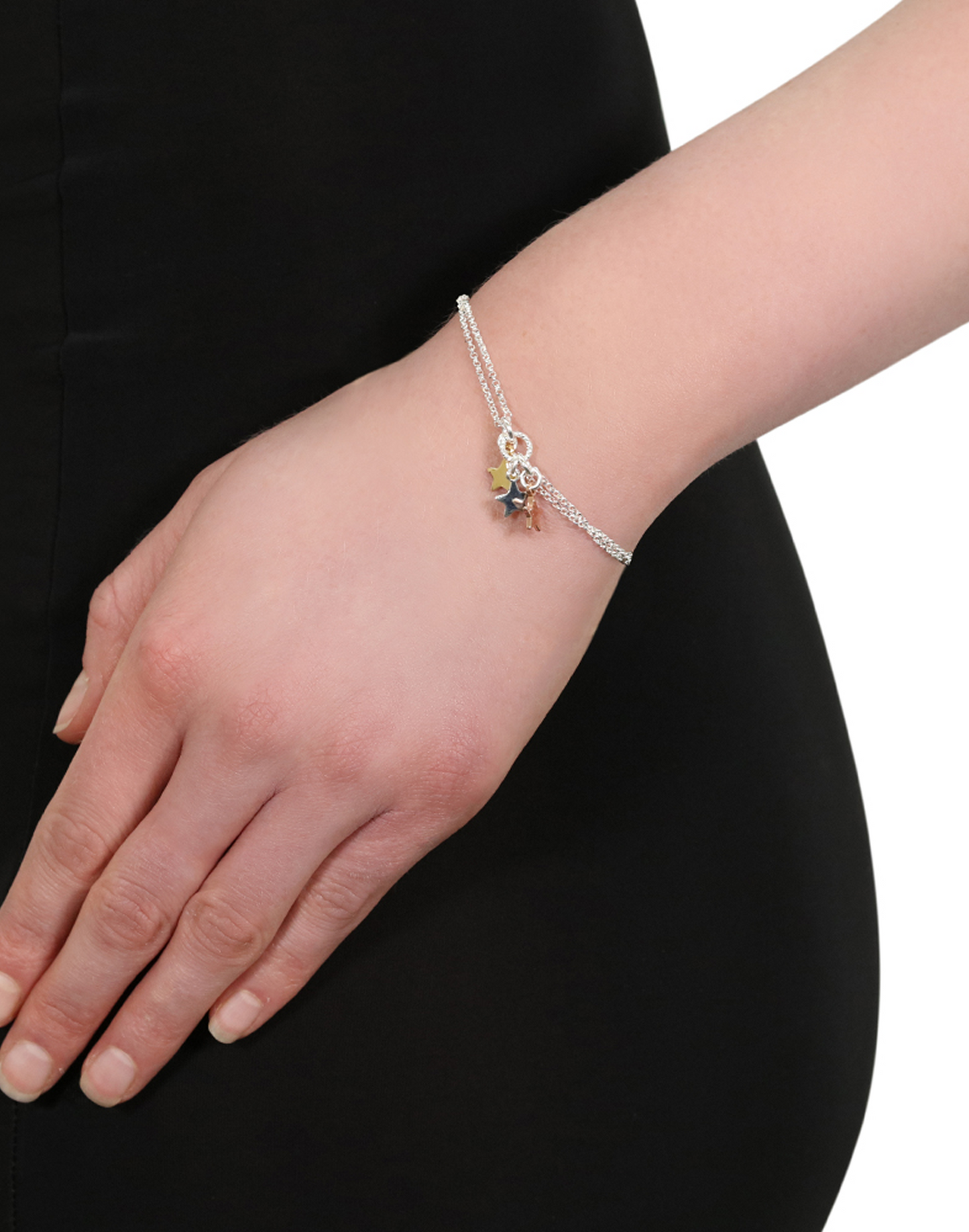 Stella star silver charm bracelet with 3 star charms on a wrist