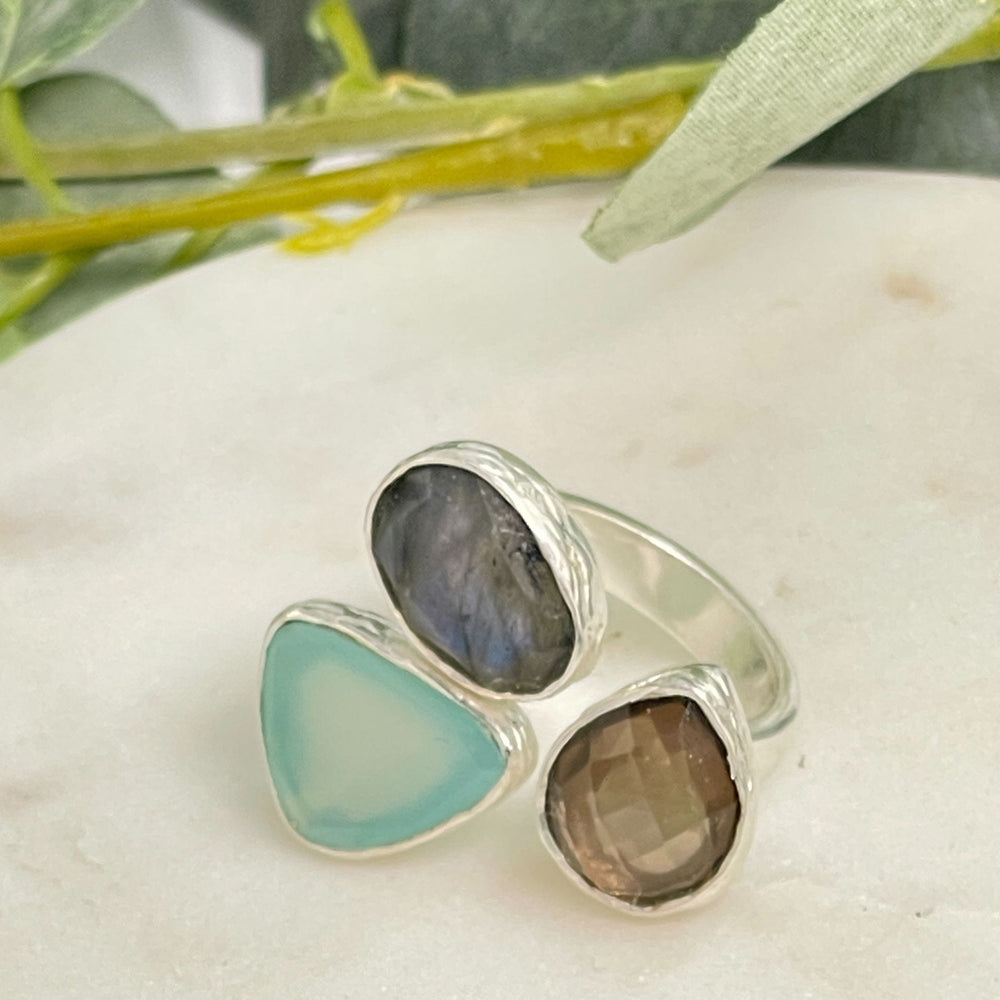 Stone and silver chunky ring on a white surface with greenery