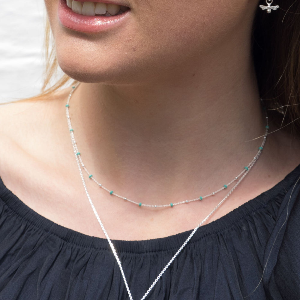 
                  
                    model wears silver t bar necklace on adjustable chain
                  
                