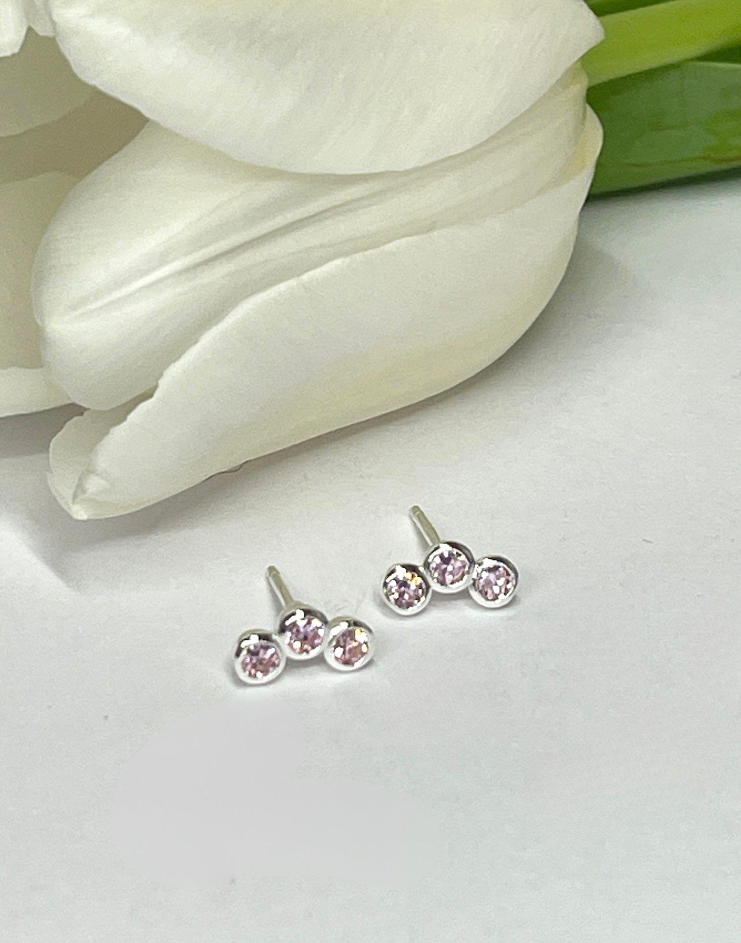 Triple cubic zirconia pink and silver studs on a tile