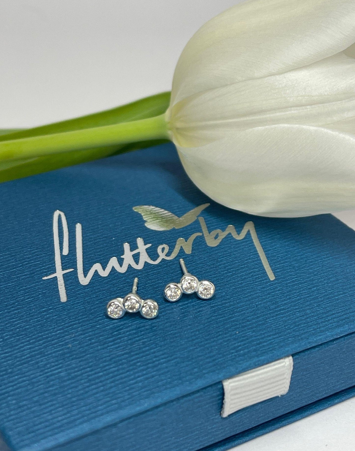 Triple cubic zirconia silver studs on gift box with flower