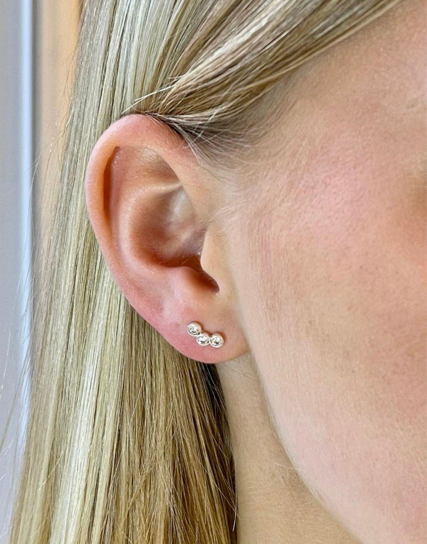 Model wears triple cubic zirconia silver studs