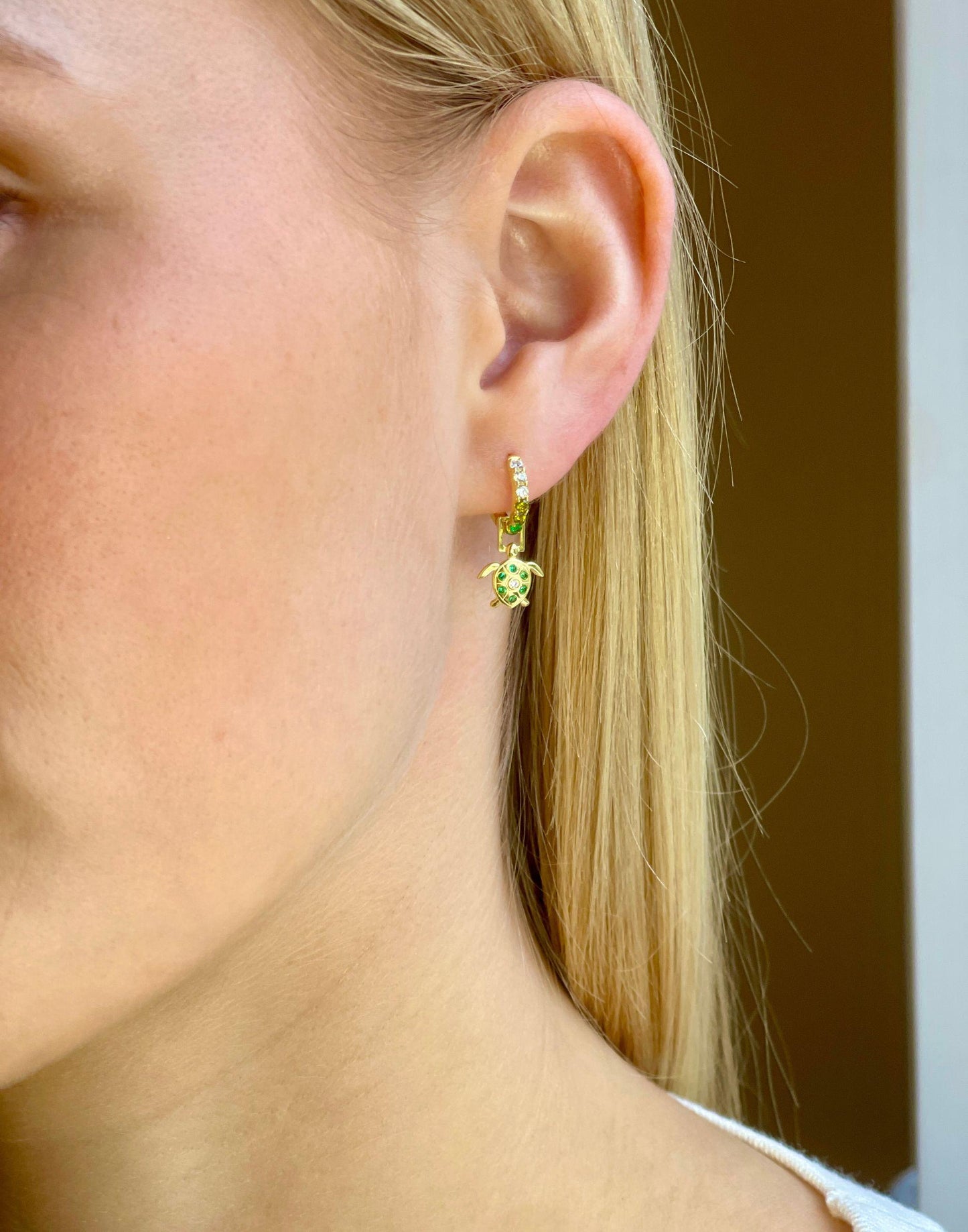 Model wears turtle gold huggie earring