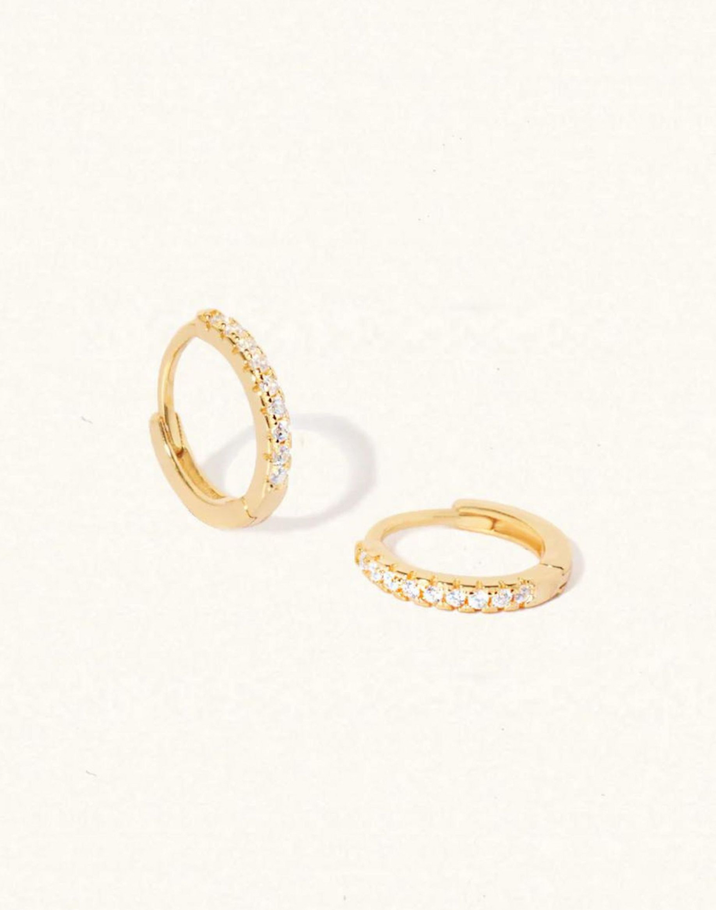 Vicky_White_Topaz_Huggie_Earrings on background