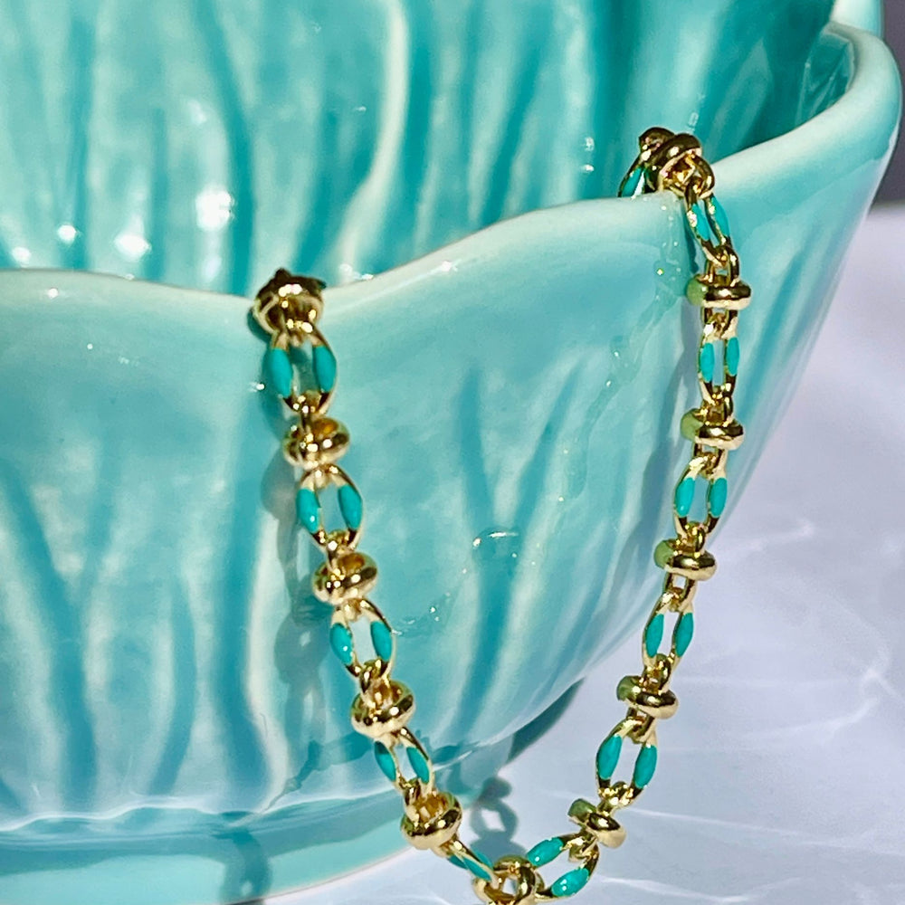 
                  
                    Blue enamel bracelet draped over a teal coloured bowl
                  
                