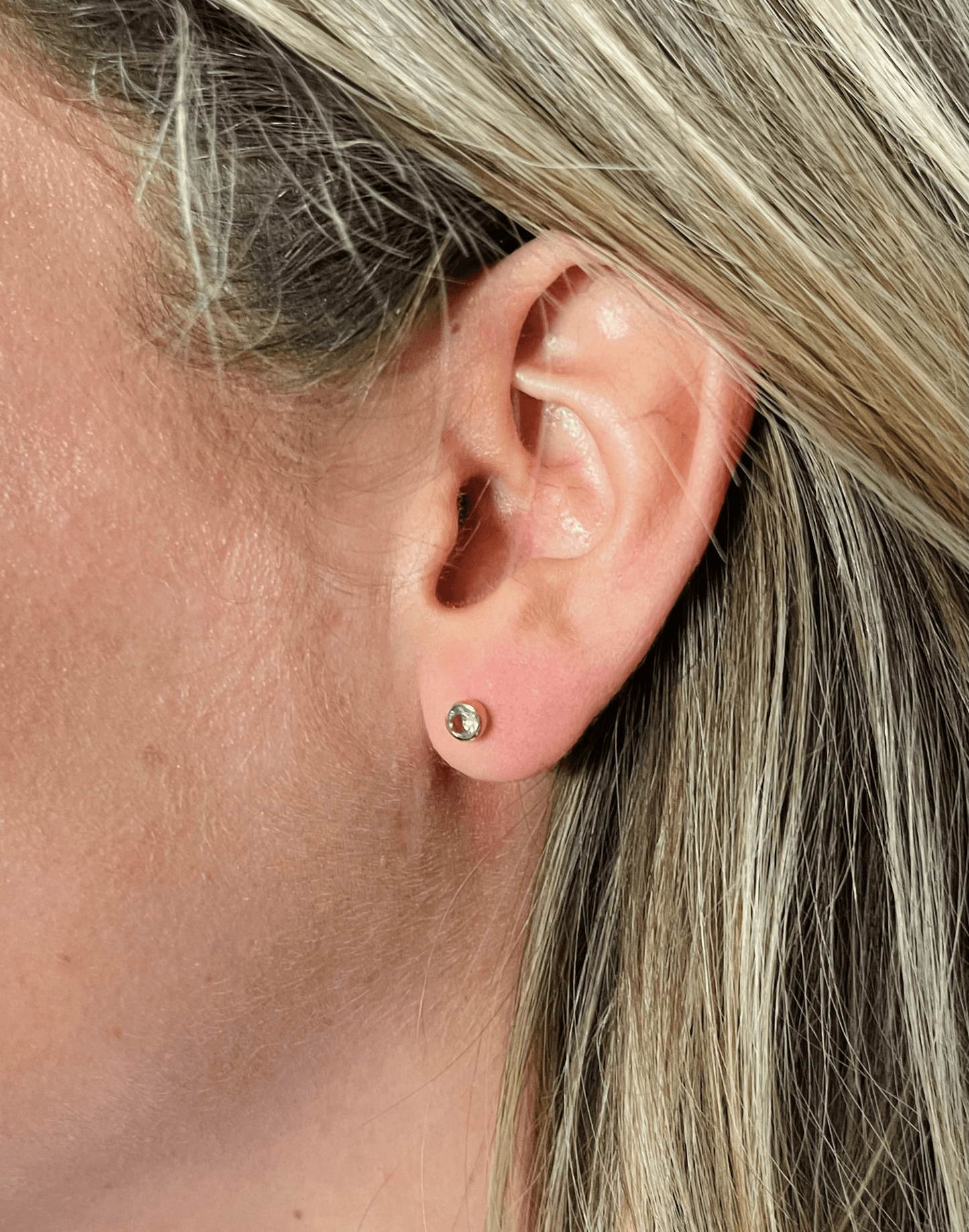blue topaz coloured birthstone studs in model's ear