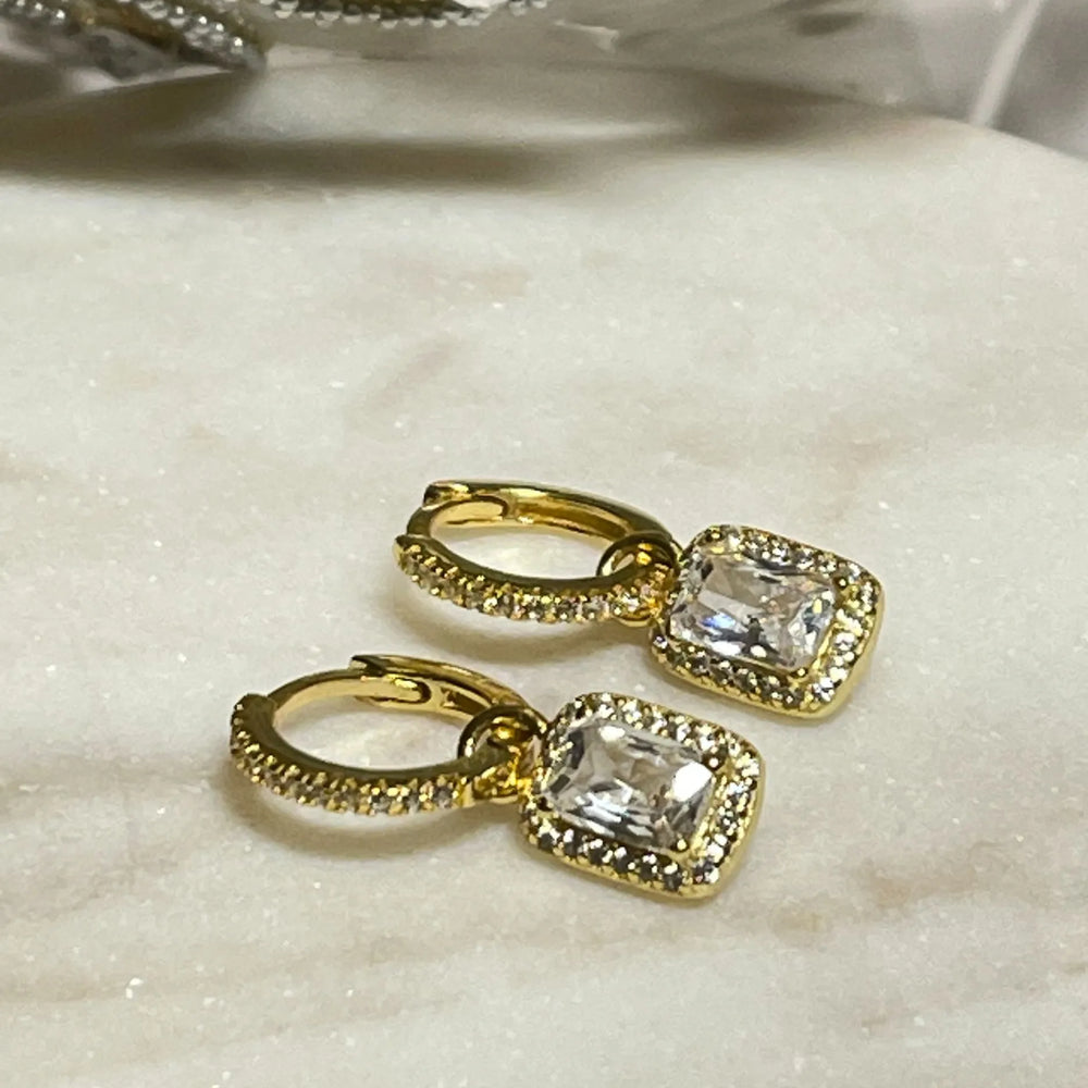 
                  
                    gold ibiza earrings on tile
                  
                
