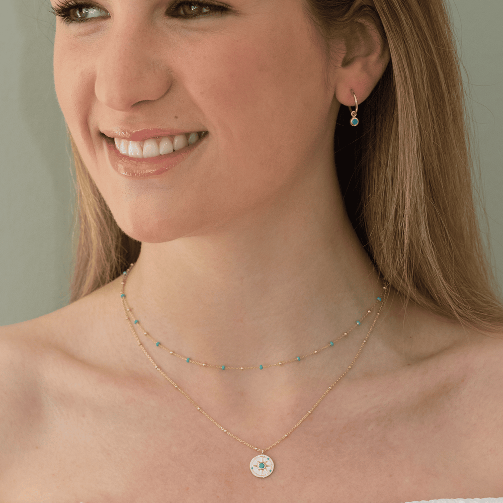 gold light turquoise enamel necklace on model