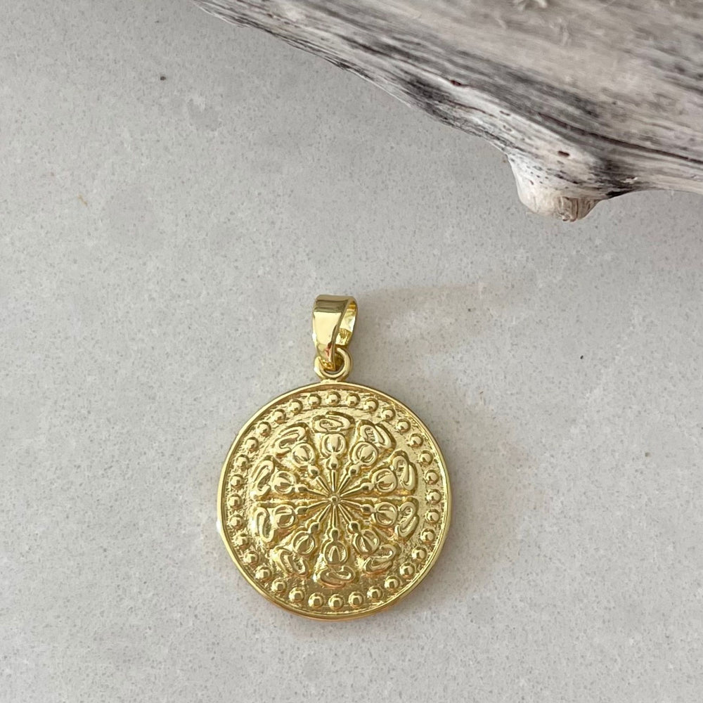 Gold Fill disc pendant on a pale tile