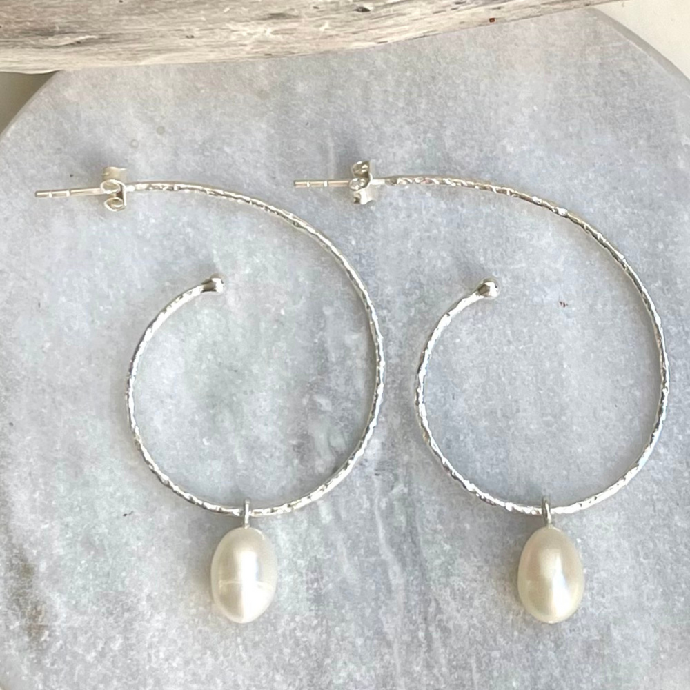 
                  
                    large silver hoop earrings on tile
                  
                