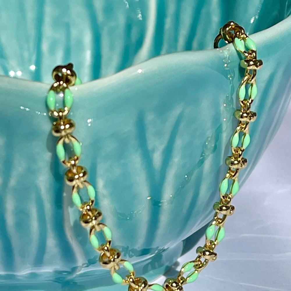 
                  
                    Mint enamel bracelet draped over a teal coloured bowl
                  
                