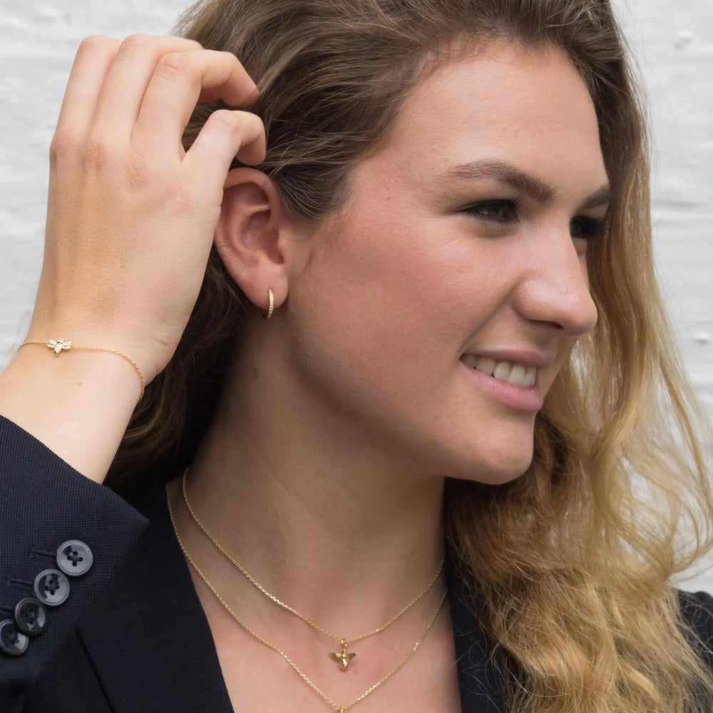 model wears vicky gold huggie earrings