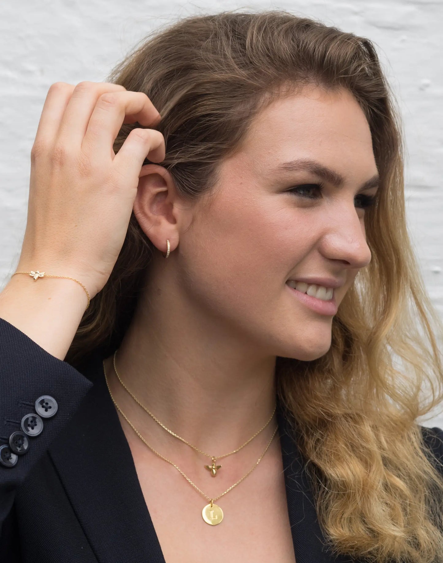 model wears vicky gold huggie earrings