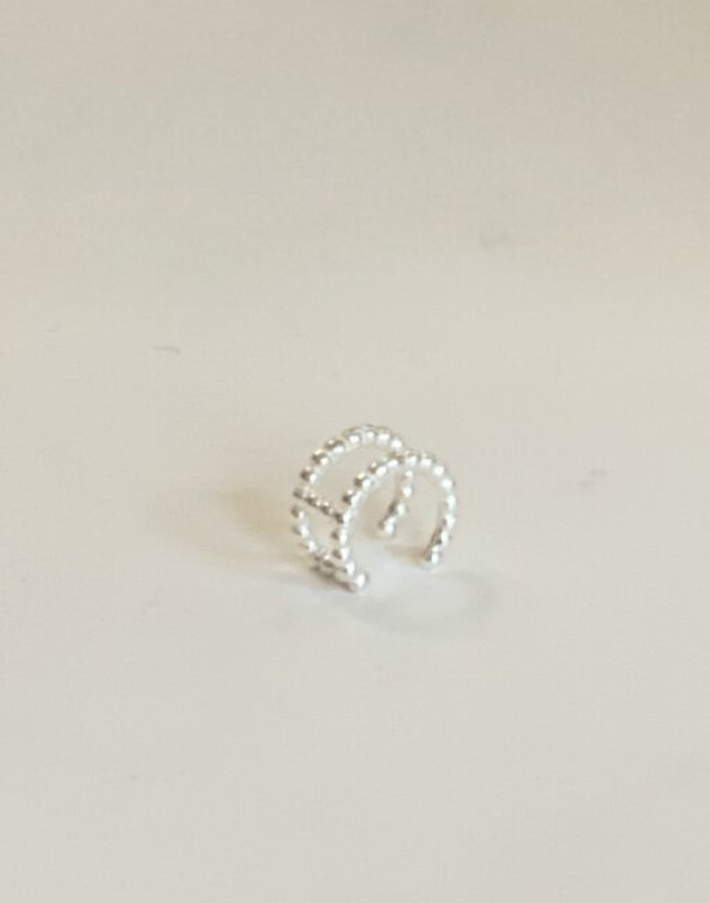 silver double row bobble ear cuff on tile
