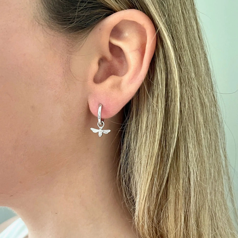 
                  
                    model wears silver bee huggie earrings
                  
                