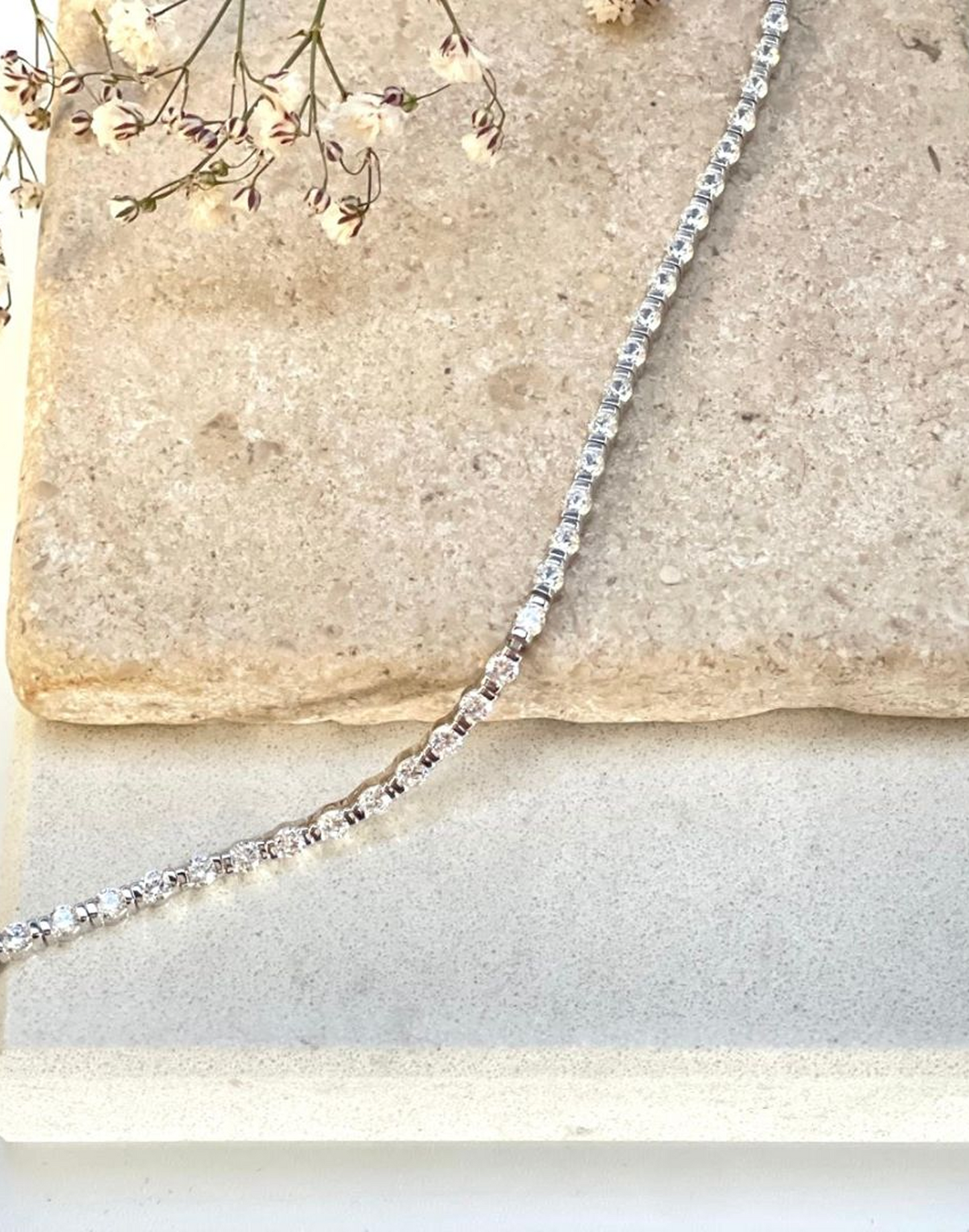 Tia Tennis Bracelet draped on a tile
