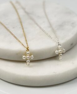 2 pearl cross necklaces sitting on a tile