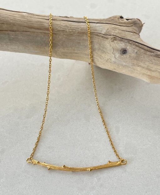 Twig Gold Necklace on tile