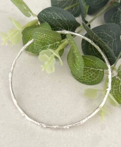 Twig silver bangle on tile