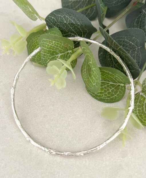 Brushed silver bangle on tile